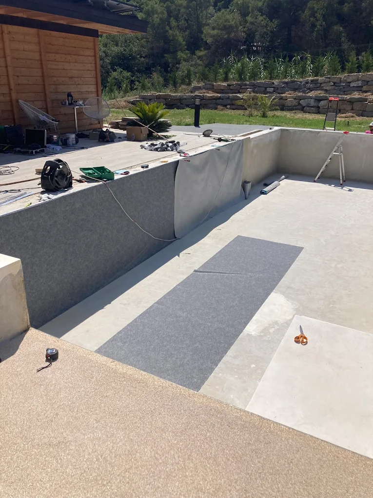 Pose de revêtement dans une piscine en travaux